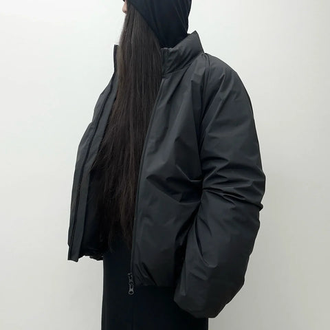Person wearing a black jacket against a white background