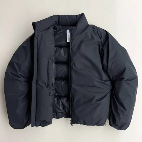 Black puffer jacket on a light beige background